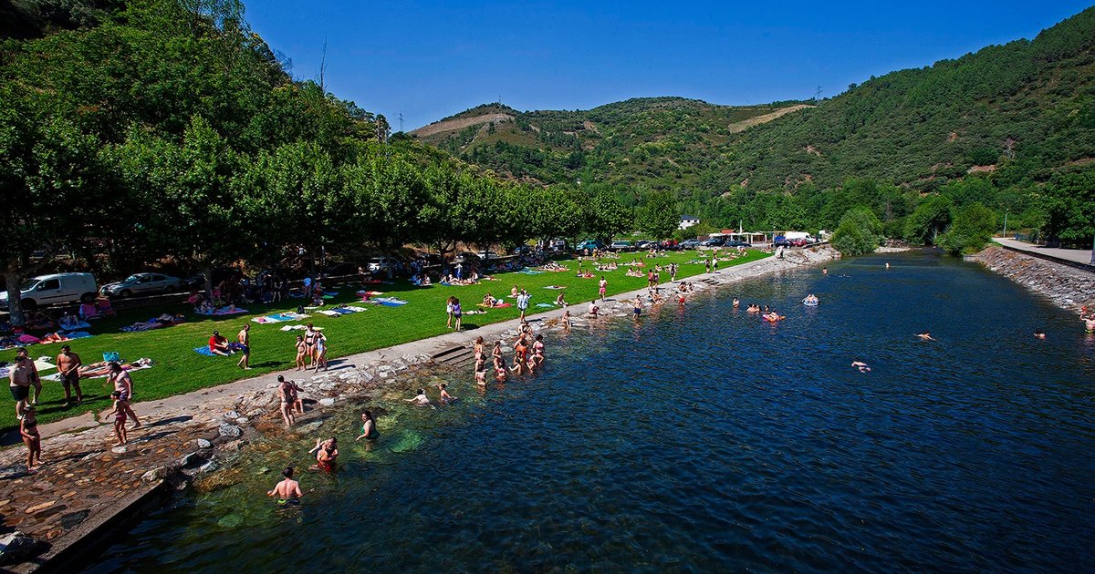 A river beach full of swimmers in the mountains of Europe